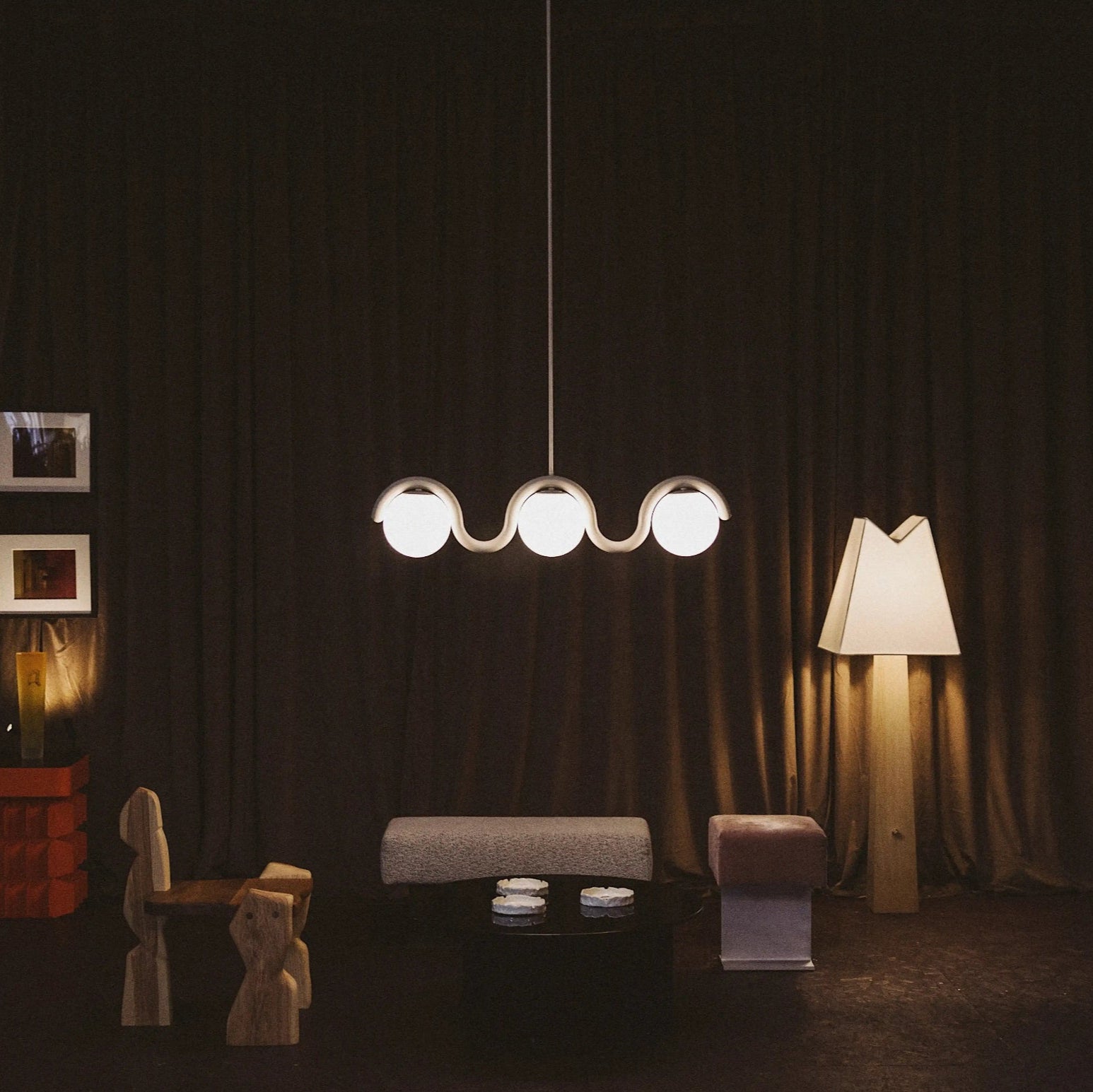 Liniowy żyrandol z falistą belką i trzema kulistymi światłami