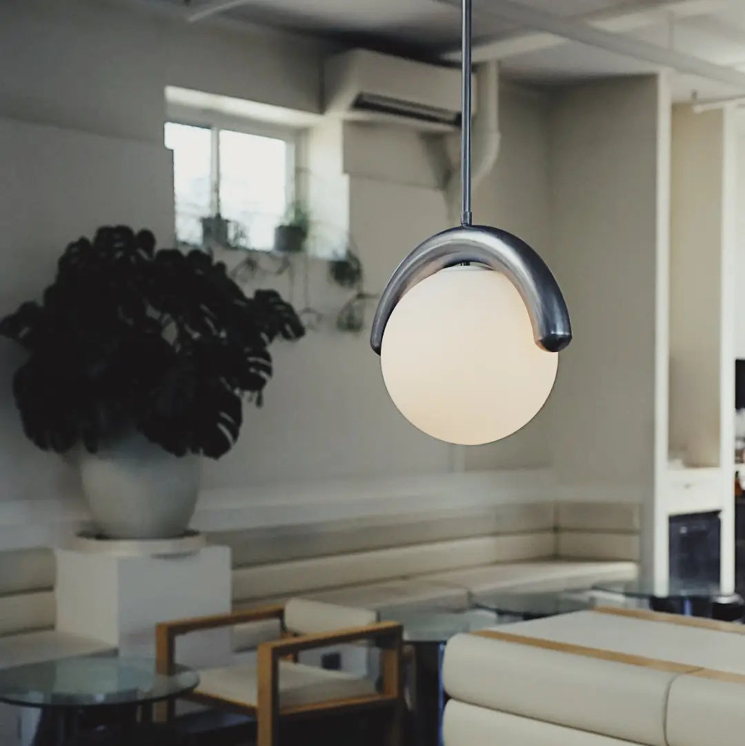 Liniowy żyrandol z falistą belką i trzema kulistymi światłami