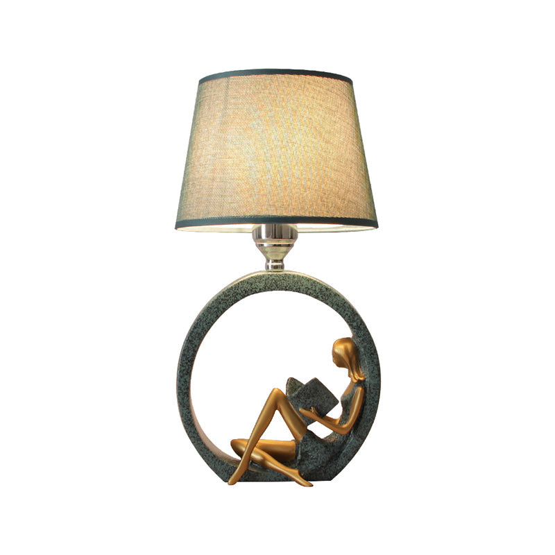 Lampe de table avec base ronde et figure assise