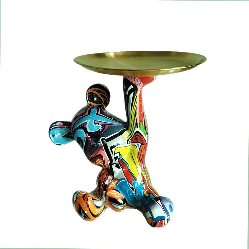 Kolorowa figurka niedźwiedzia trzymająca okrągłą tackę